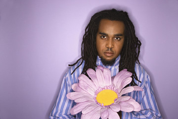 african-american man holding big fake flower.