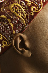 close-up of man's ear and african hat.