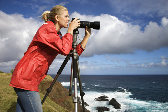 woman photographing scenery in maui, hawaii.
