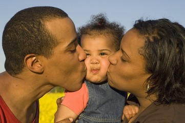 Fototapeta premium parents kissing their cute little baby