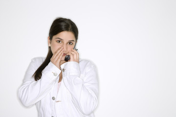 caucasian teen girl whispering  into cellphone.