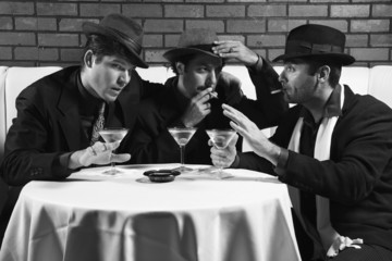 three retro businessmen drinking, smoking and talking.
