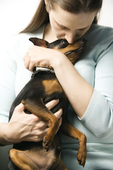 Caucasian woman and Miniature Pinscher dog.