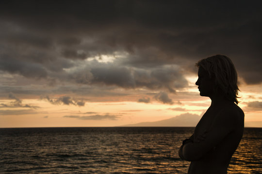 Teen boy looking at Maui Hawaii ocean.