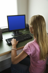 Pre-teen girl working at computer.
