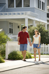 Fototapeta premium Couple walking on sidewalk.