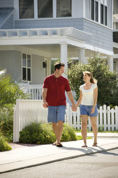 Couple Walking On Sidewalk.