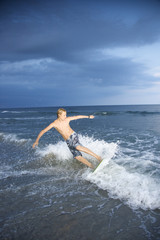 Naklejka premium Male teen riding skimboard.