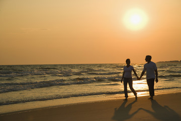 Fototapeta na wymiar Couple holding hands at sunset.