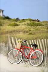 Fototapeta premium Bike leaning against fence at beach.