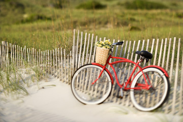 Bike leaning against fence at beach. - Powered by Adobe