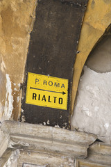 Sign with arrow pointing direction to Rialto in Venice, Italy.