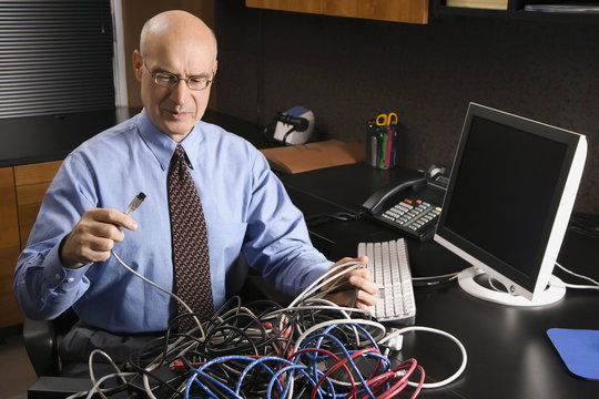 Caucasian Businessman With A Tangle Of Computer Cables.