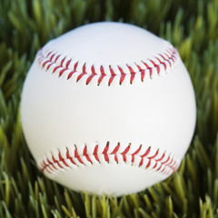 close-up of baseball resting in grass.