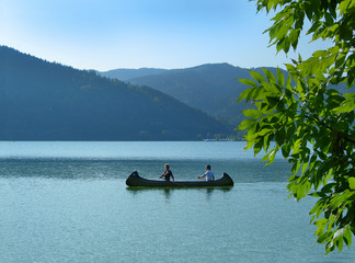 women paddling canoe on lake