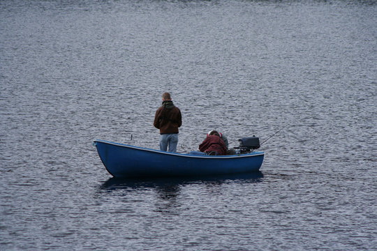 men fishing in small boat on a lake