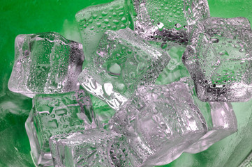 melting ice cubes closeup  on green background (b7