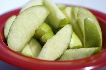 red bowl with green apple slices