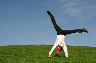 businessman doing cartwheel outdoors