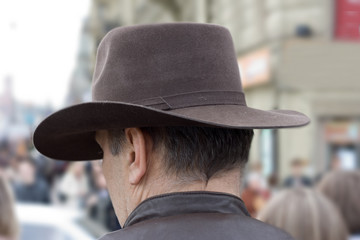 man in cowboy hat on street street back head crowd