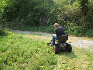 farm worker using ride on mower