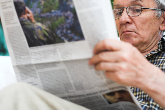 man read newspapers