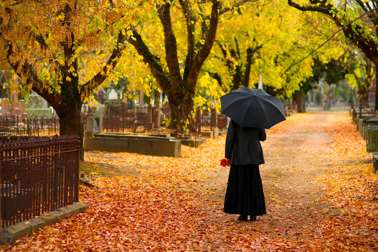 woman in mourning at cemetery in fall