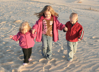 three kids walking together at beach