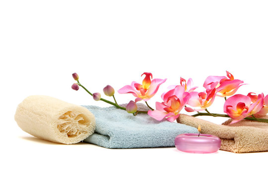 spa towels, loofah, candle and pink orchid
