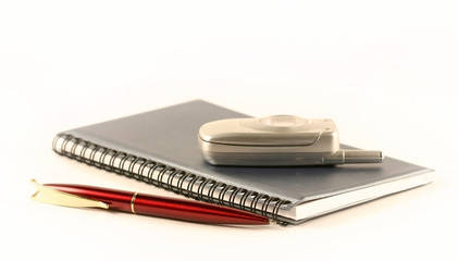 the pen, notebook and  mobile phone