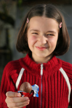Young gril is holding chocolate egg at easter
