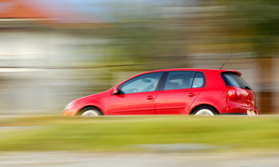 Plakat szybko poruszających się czerwony samochód