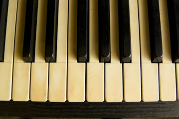 antique piano with yellowish old keyboard.