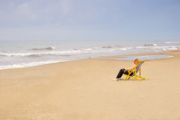Fototapeta na wymiar woman in chair on sea beach