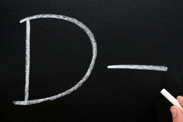 a teacher writing d- on a blackboard.
