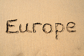 europe, written on a sandy beach.