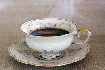 antique cup with hot steaming coffee