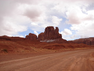 Fototapeta na wymiar pink clouds and a dirt track in monument valley