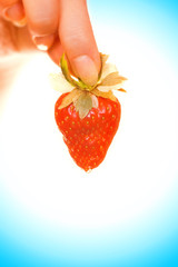 woman's hand with a fresh juicy strawberry