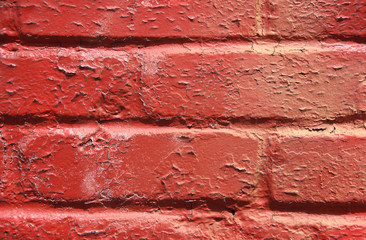 red peeling paint on a brick wall