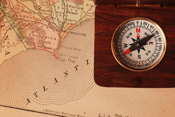 antique wooden compass over old usa map