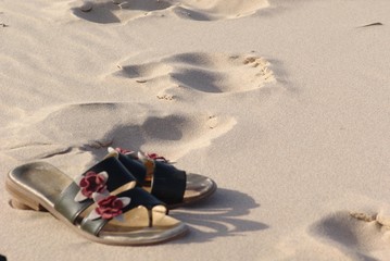 shoes with footsteps on the beach