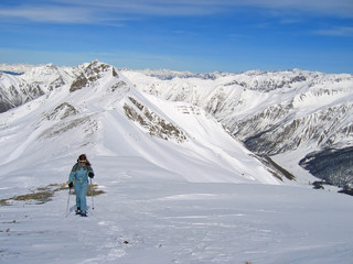 Fototapeta na wymiar Kobieta górskich trekker na rakietach śnieżnych, Les Orres, Alpy, Francja