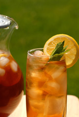 glass of iced tea with a pitcher of tea alongside