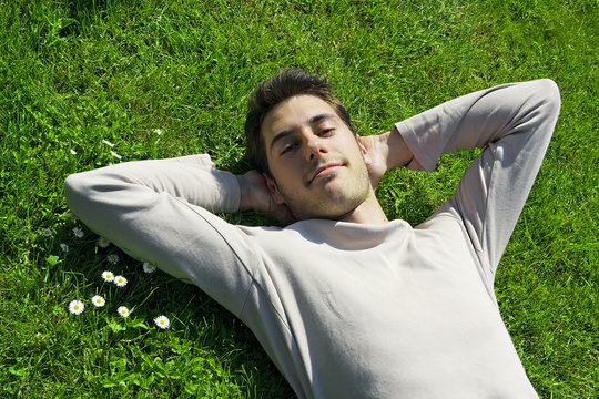 jeune homme sourire détente relaxation l' herbe
