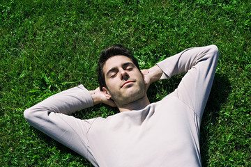 jeune homme sieste dans l'herbe repos relaxation