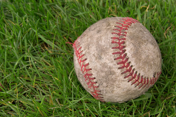dirty baseball in grass