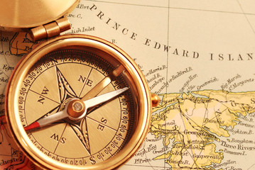 antique brass compass over old canadian map
