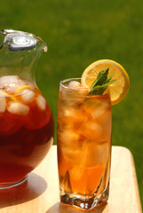 glass of iced tea with pitcher of tea next to it