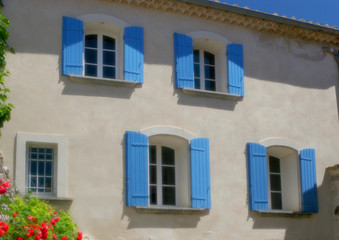 Fototapeta na wymiar dom z niebieskimi okiennicami